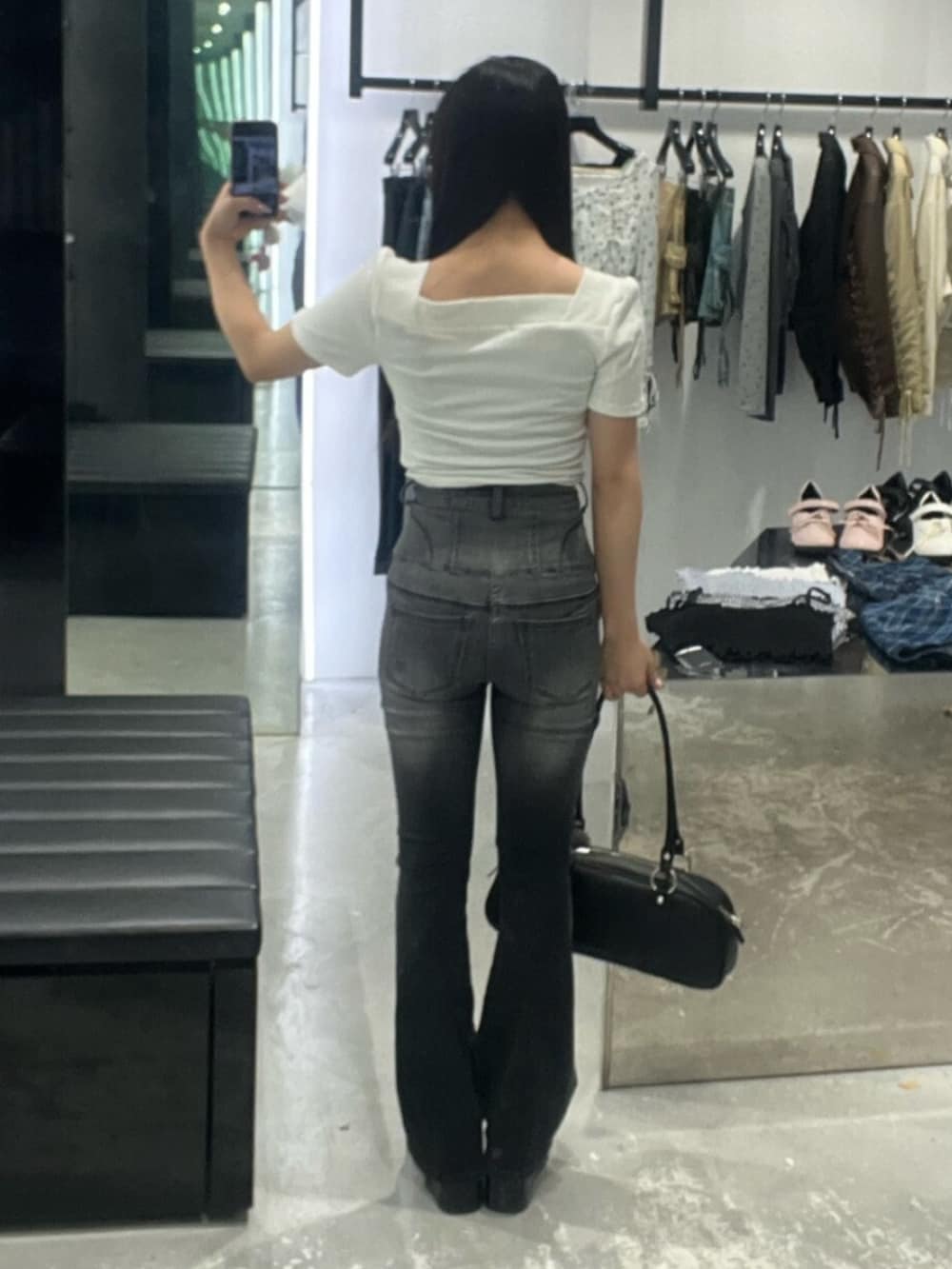 ブラック系のデニムパンツ、ブラック系のサンダル、ホワイト系のTシャツ/カットソーを着用したレディースの春コーディネートの3枚目の写真