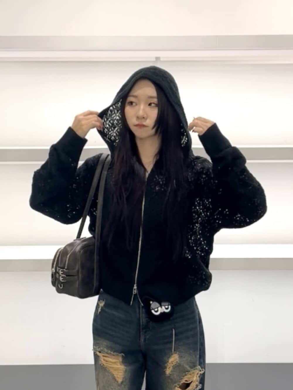 ホワイト系のスニーカー、ブルー系のデニムパンツ、ブラック系のパーカーを着用したレディースの春コーディネートの5枚目の写真