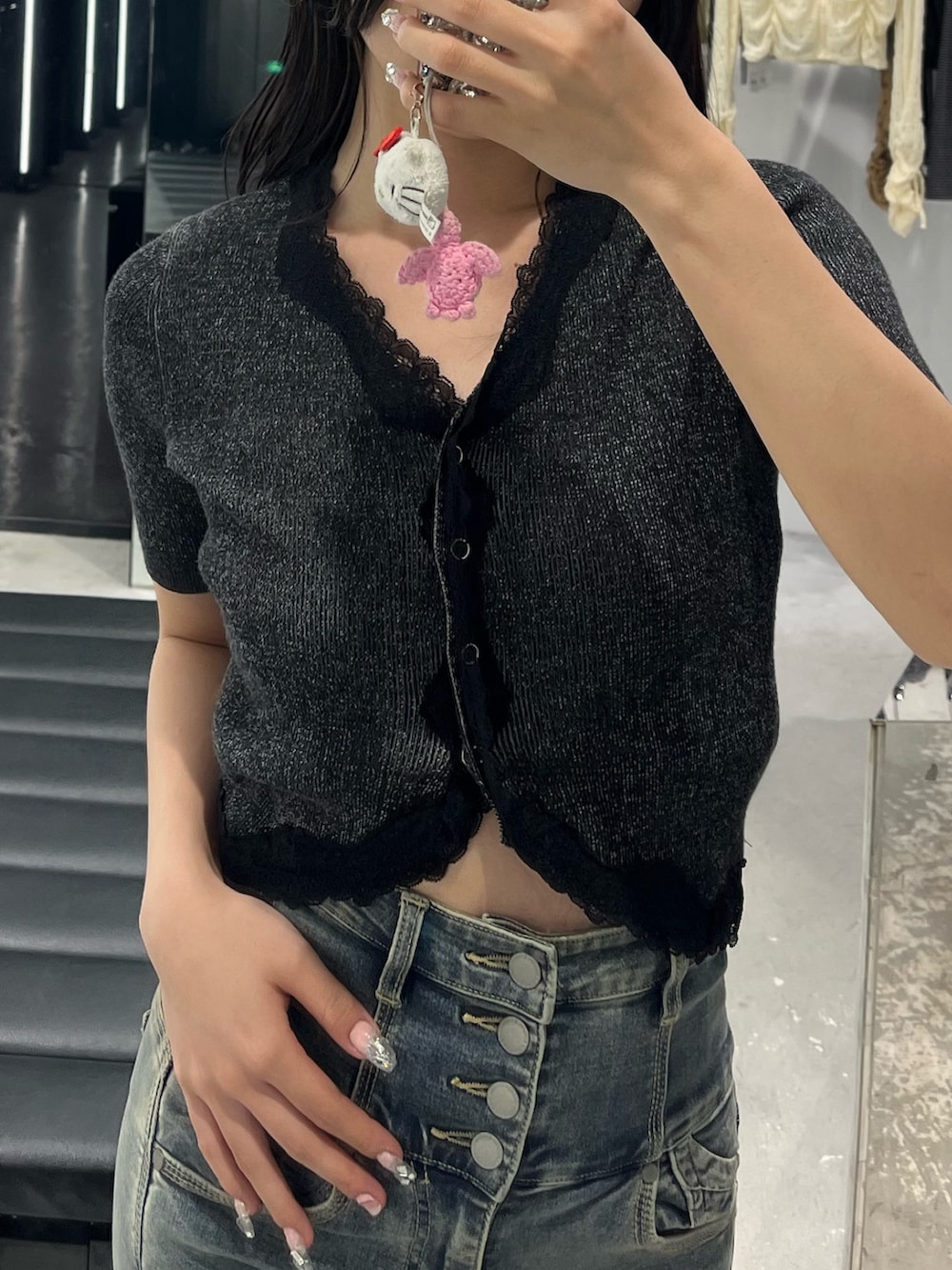 ブラック系のニット/セーター、ブルー系のデニムパンツ、ブラック系のサンダルを着用したレディースの春コーディネートの4枚目の写真