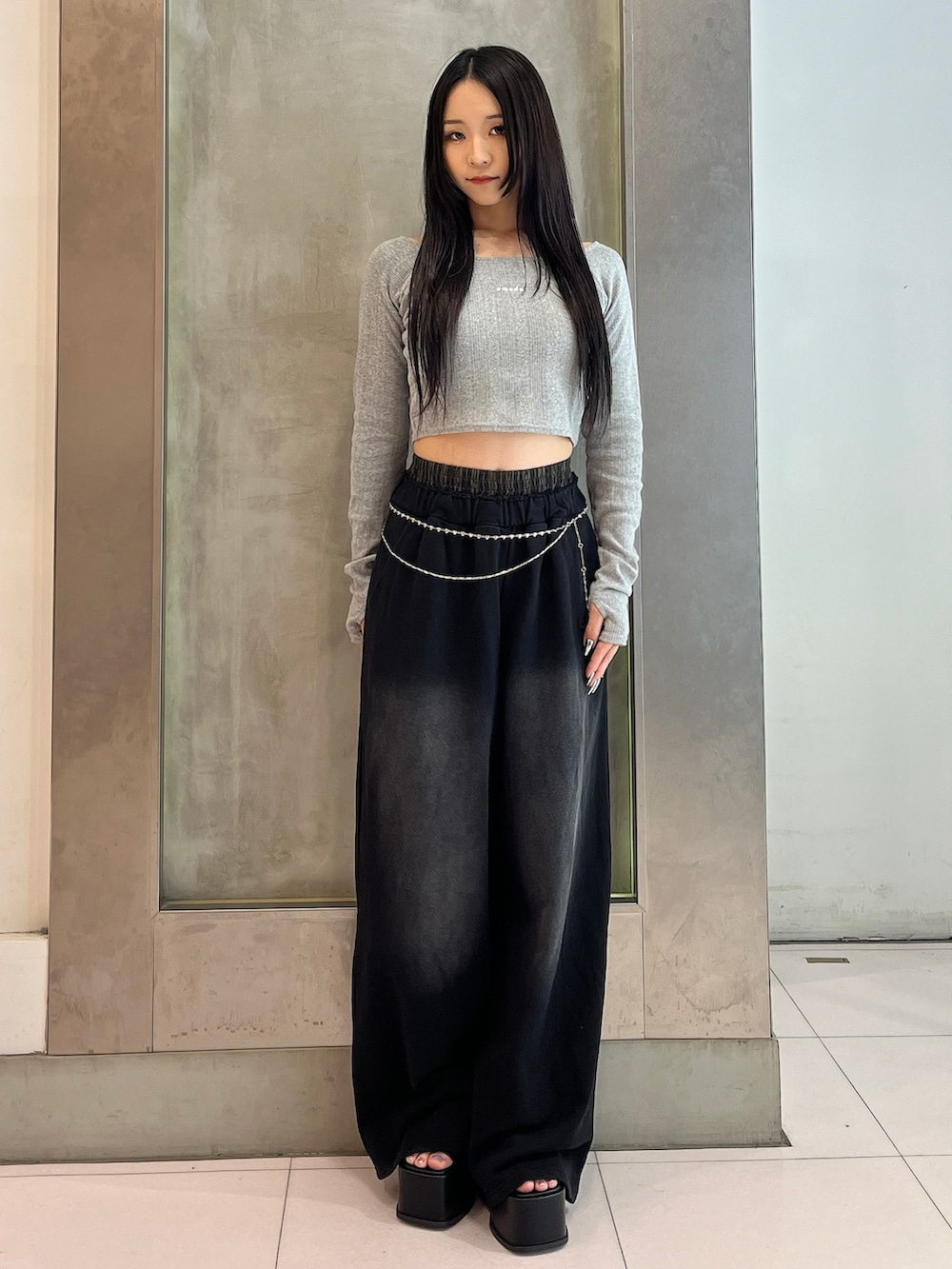 グレー系のTシャツ/カットソー、ブラック系のスウェットパンツ、ブラック系のサンダルを着用したレディースの春コーディネートの2枚目の写真