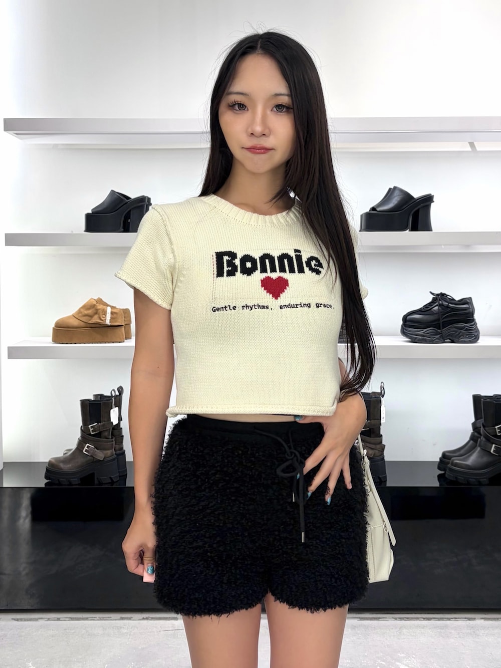 ホワイト系のニット/セーター、ホワイト系のハンドバッグ、ブラック系のその他パンツを着用したレディースの夏コーディネートの4枚目の写真