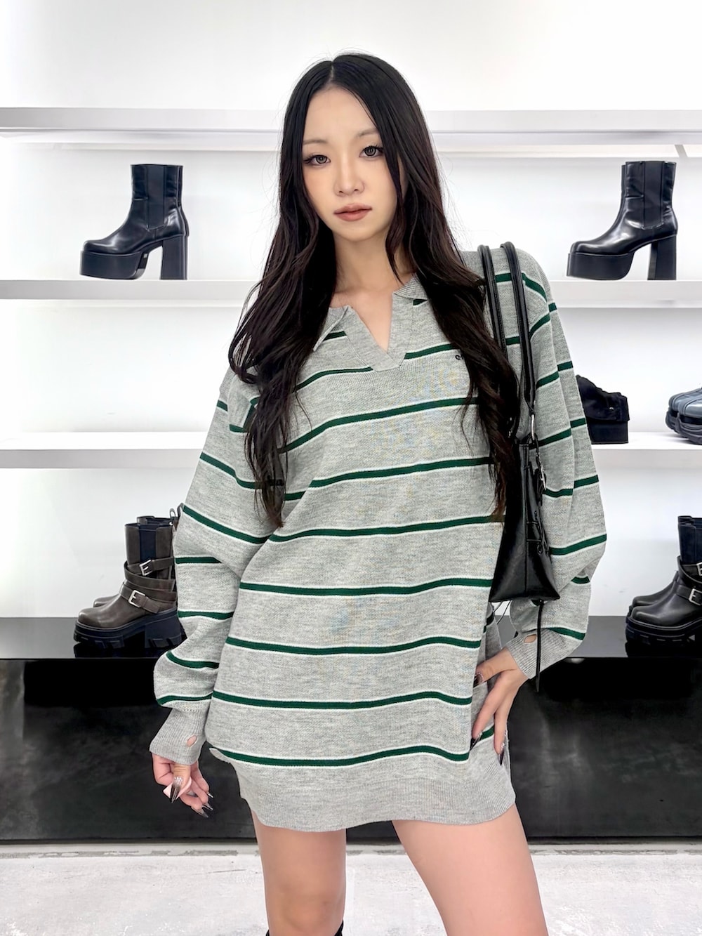 グレー系のワンピース、ブラック系のショルダーバッグ、ブラック系のブーツを着用したレディースの秋コーディネートの5枚目の写真