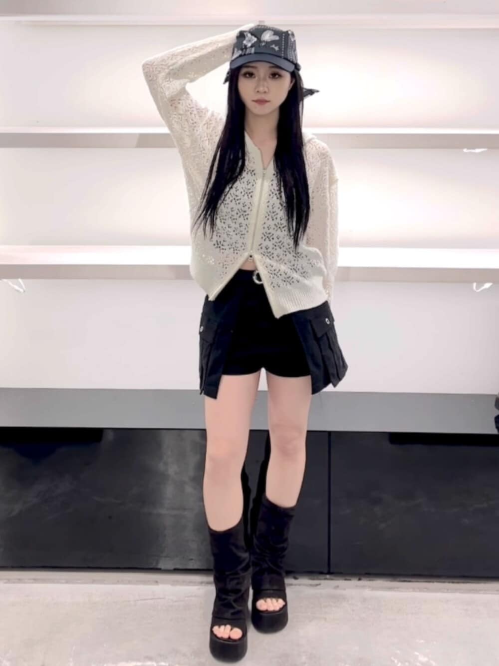 ブラック系のサンダル、ホワイト系のパーカー、ブラック系のスカートを着用したレディースの春コーディネートの8枚目の写真