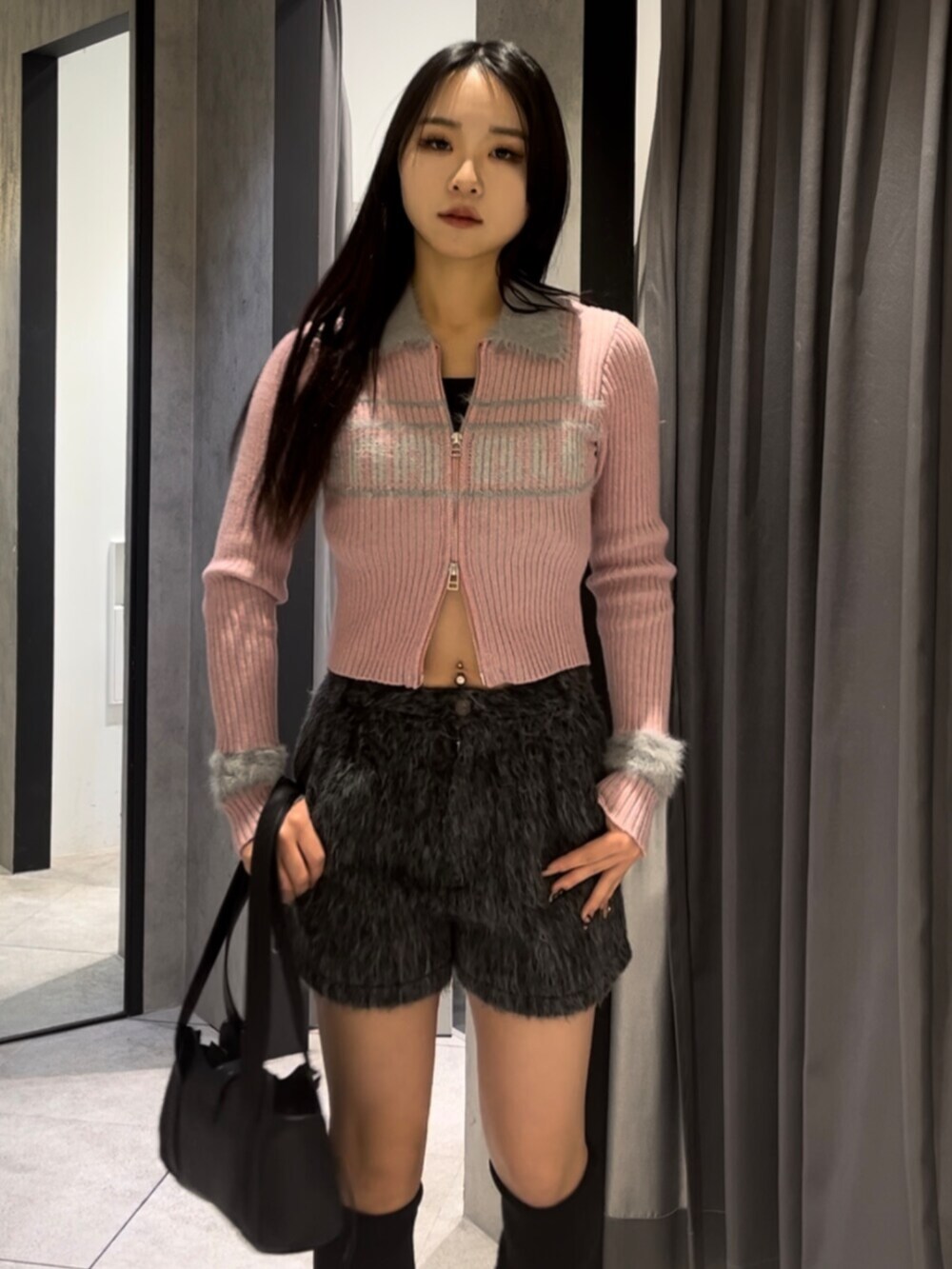 ブラック系のハンドバッグ、ブラック系のブーツ、グレー系のその他パンツを着用したレディースの冬コーディネートの4枚目の写真