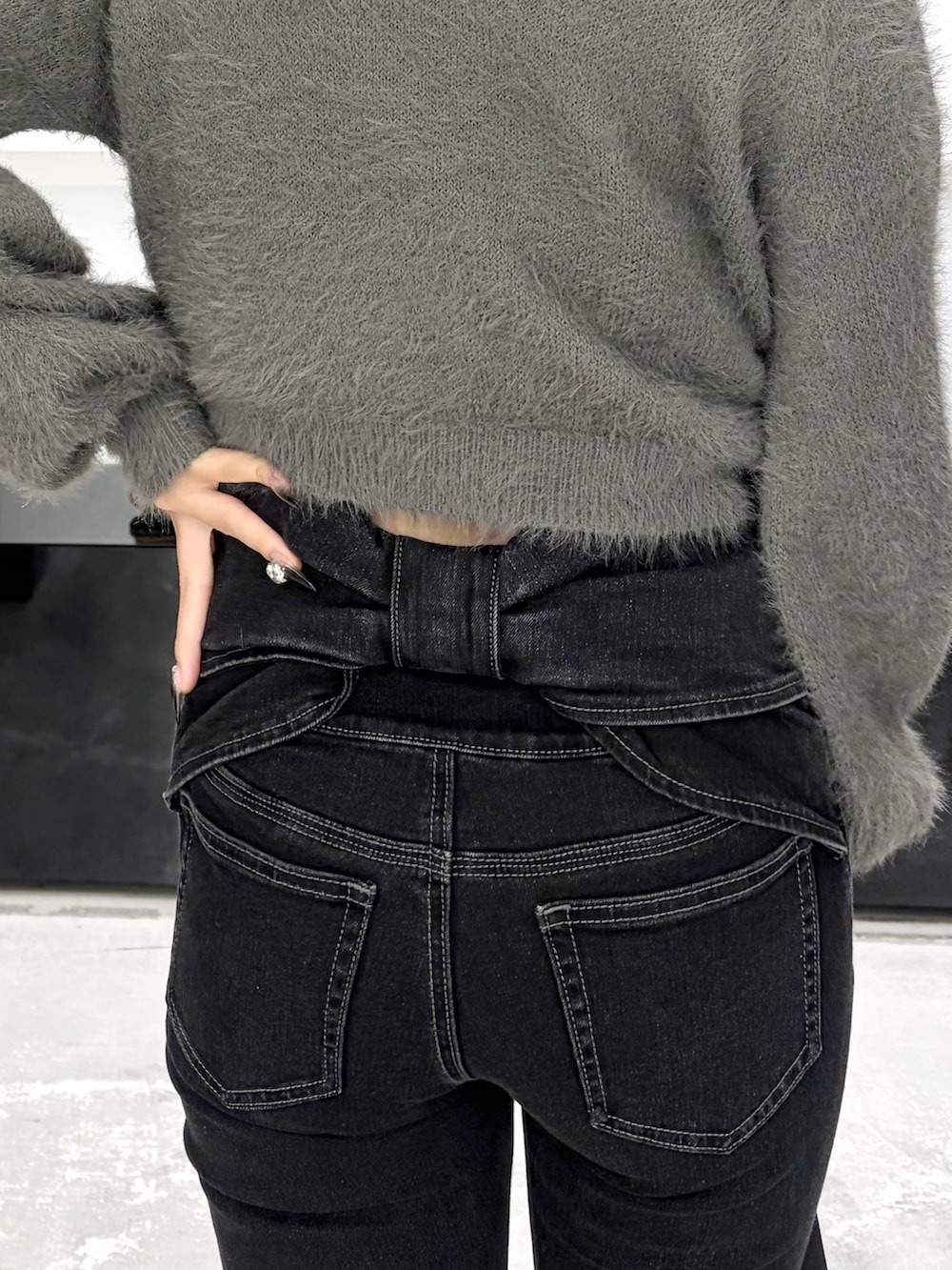 グレー系のニット/セーター、ブラック系のデニムパンツ、ブラック系のショルダーバッグを着用したレディースの秋コーディネートの8枚目の写真
