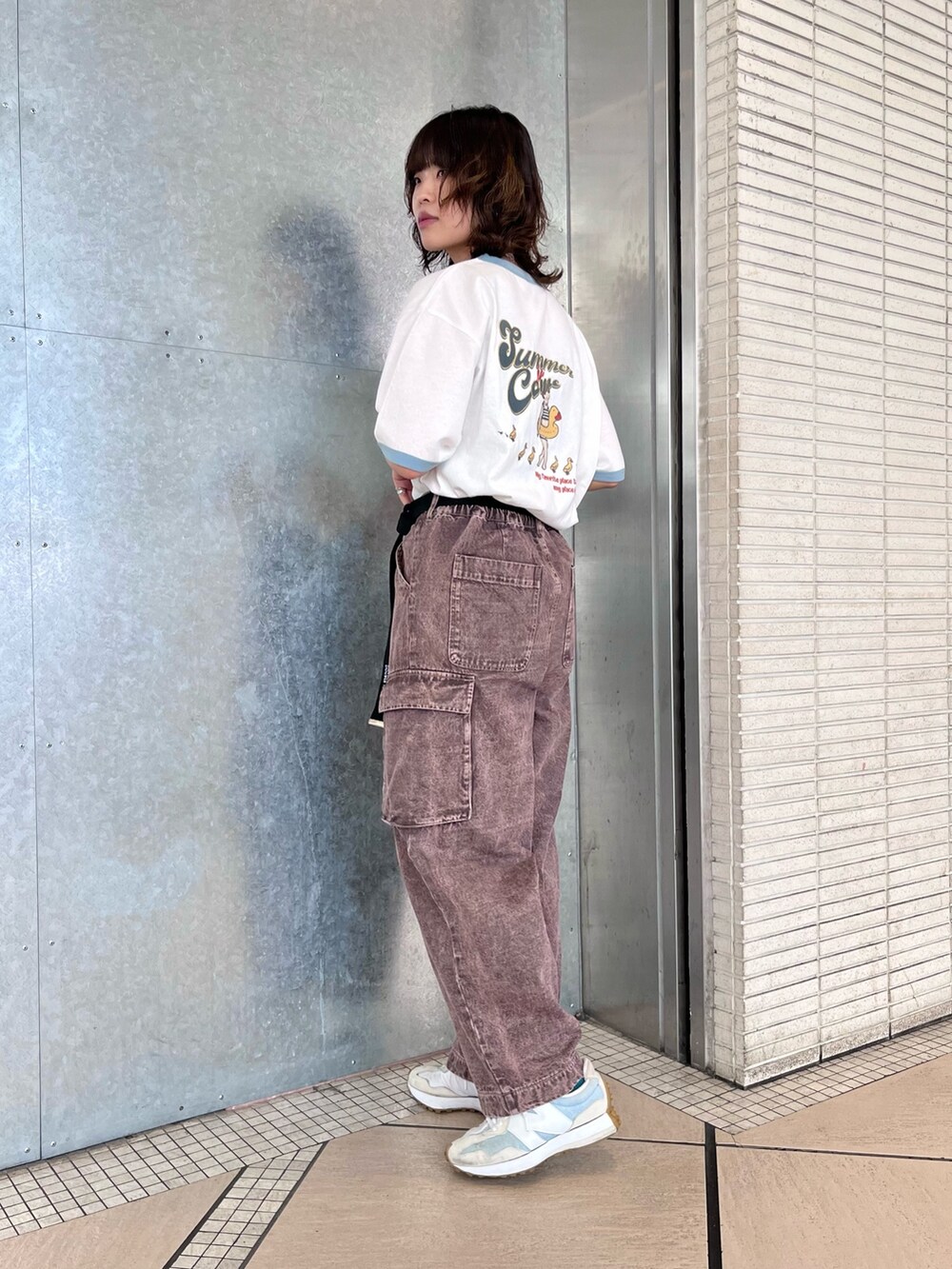 ブラウン系のデニムパンツ、ホワイト系のTシャツ/カットソー、ブラック系のベルトを着用したレディースの夏コーディネートの2枚目の写真