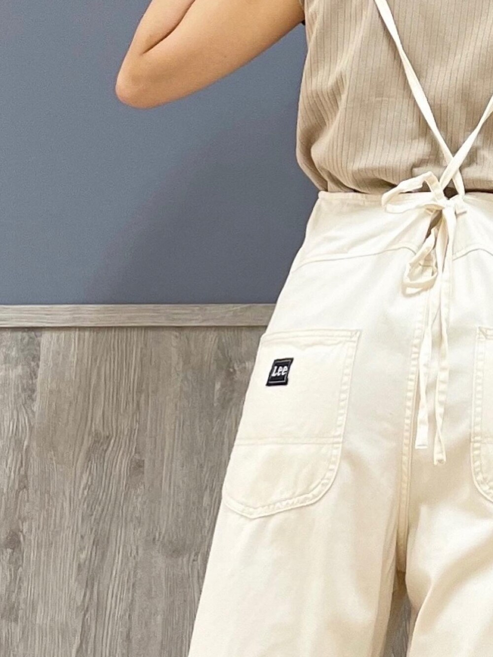 ベージュ系のショルダーバッグ、オレンジ系のカーディガン/ボレロ、ホワイト系のサロペット/オーバーオールを着用したレディースの夏コーディネートの4枚目の写真