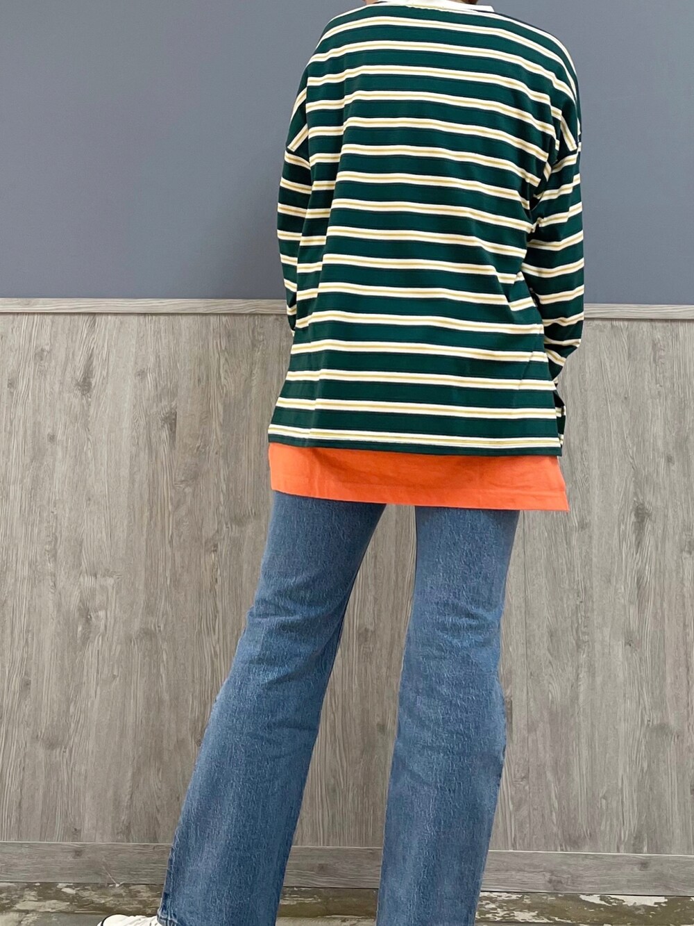 レッド系のトートバッグ、ブルー系のデニムパンツ、グリーン系のTシャツ/カットソーを着用したレディースの春コーディネートの4枚目の写真