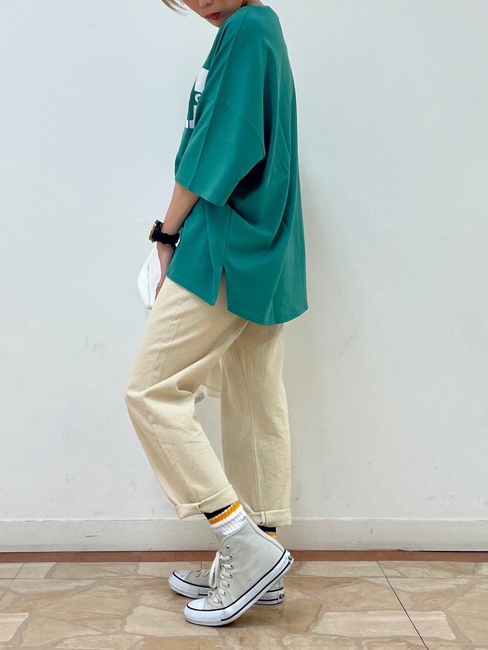 ホワイト系のデニムパンツ、グリーン系のTシャツ/カットソー、ベージュ系のトートバッグを着用したレディースの夏コーディネートの4枚目の写真