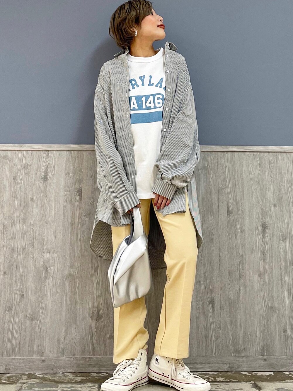 シルバー系のショルダーバッグ、ホワイト系のジャケット/アウター、ブルー系のシャツ/ブラウスを着用したレディースの冬コーディネートの3枚目の写真