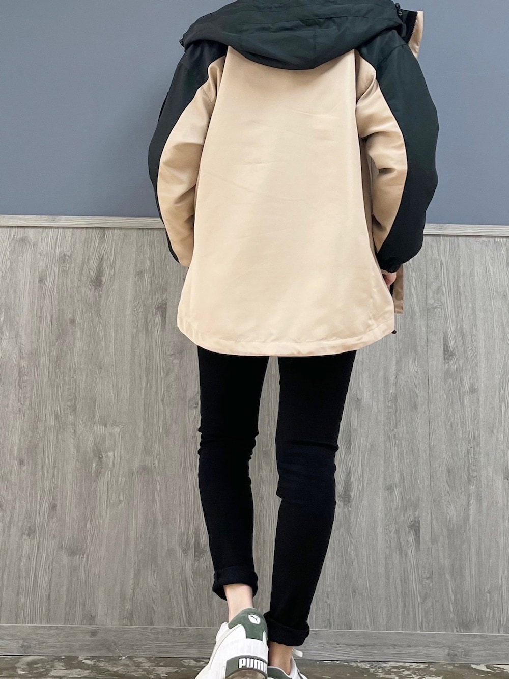 ブラック系のデニムパンツ、ベージュ系のマウンテンパーカー、ベージュ系のショルダーバッグを着用したレディースの冬コーディネートの3枚目の写真