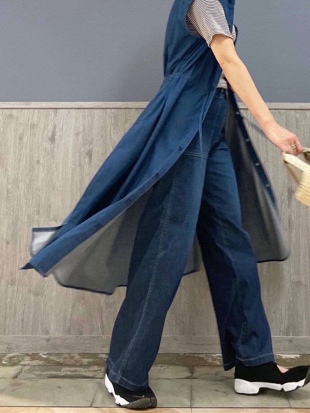 ベージュ系のショルダーバッグ、ブルー系のデニムパンツ、ブラウン系のTシャツ/カットソーを着用したレディースの夏コーディネートの3枚目の写真