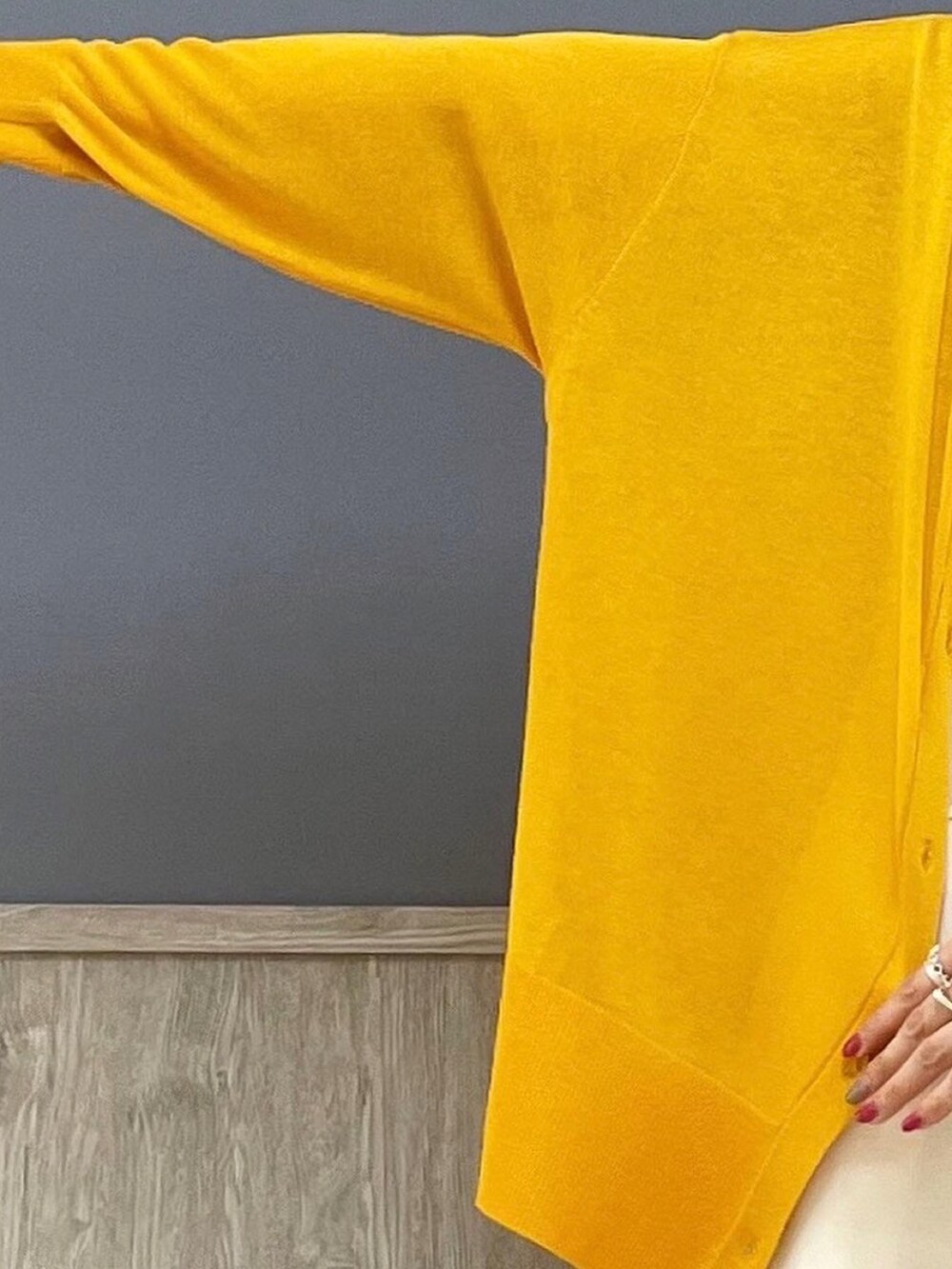 ベージュ系のショルダーバッグ、オレンジ系のカーディガン/ボレロ、ホワイト系のサロペット/オーバーオールを着用したレディースの夏コーディネートの2枚目の写真