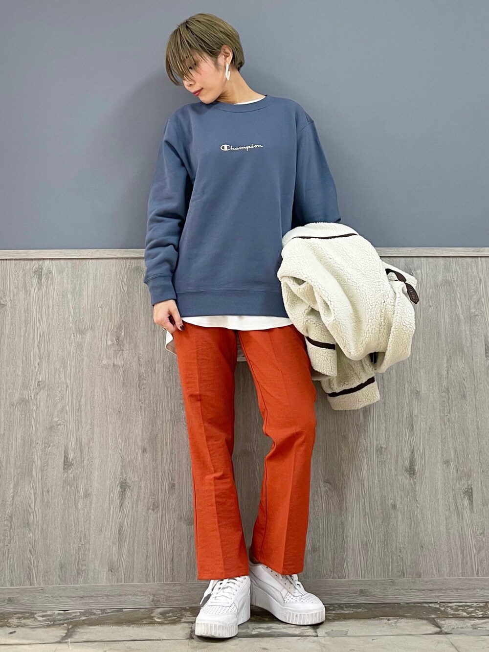 オレンジ系のスラックス、ブルー系のパーカー、ホワイト系のその他アウターを着用したレディースの秋コーディネートの4枚目の写真