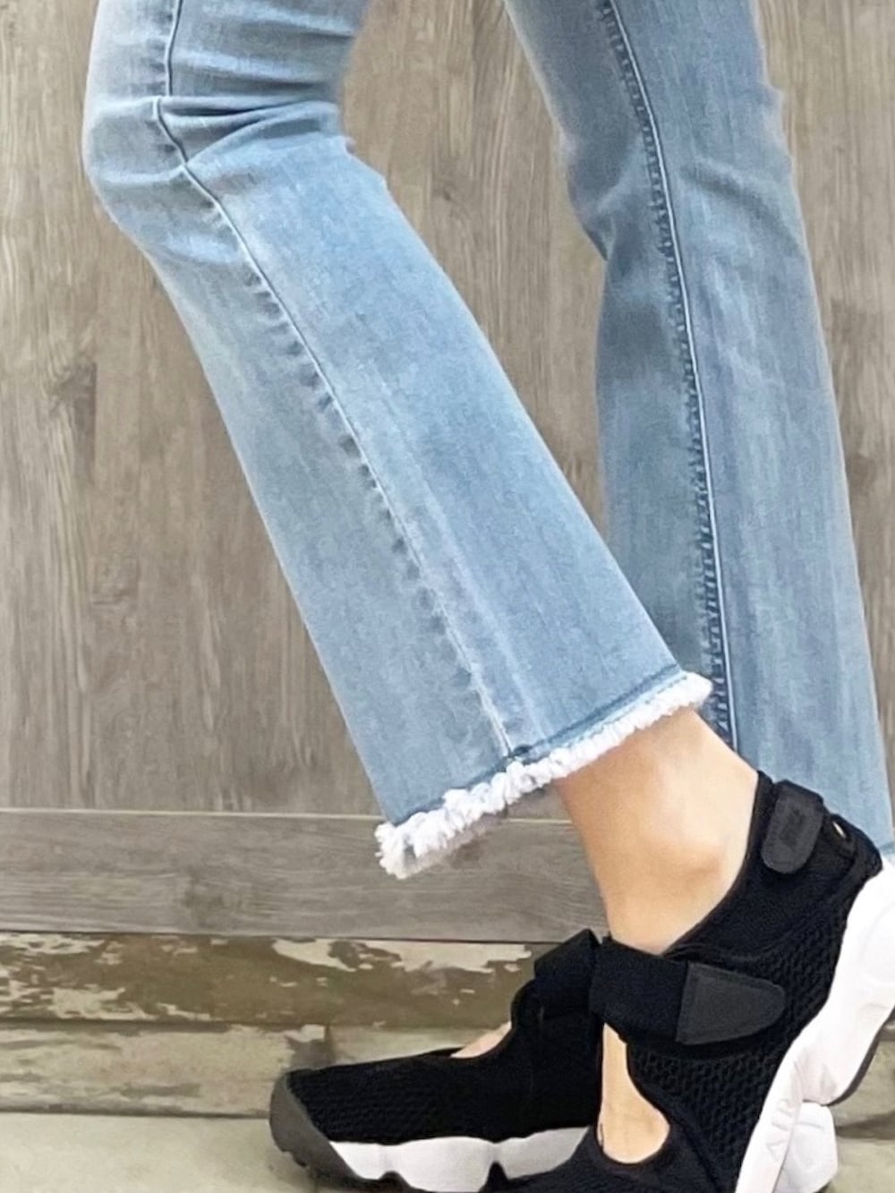 ブラック系のトップス、ブルー系のデニムパンツ、ブラック系のショルダーバッグを着用したレディースの夏コーディネートの4枚目の写真