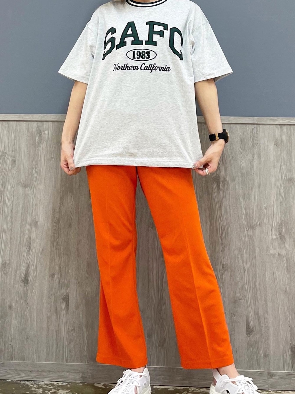 グレー系のTシャツ/カットソー、オレンジ系のパンツ、ブラウン系のショルダーバッグを着用したレディースの春コーディネートの4枚目の写真