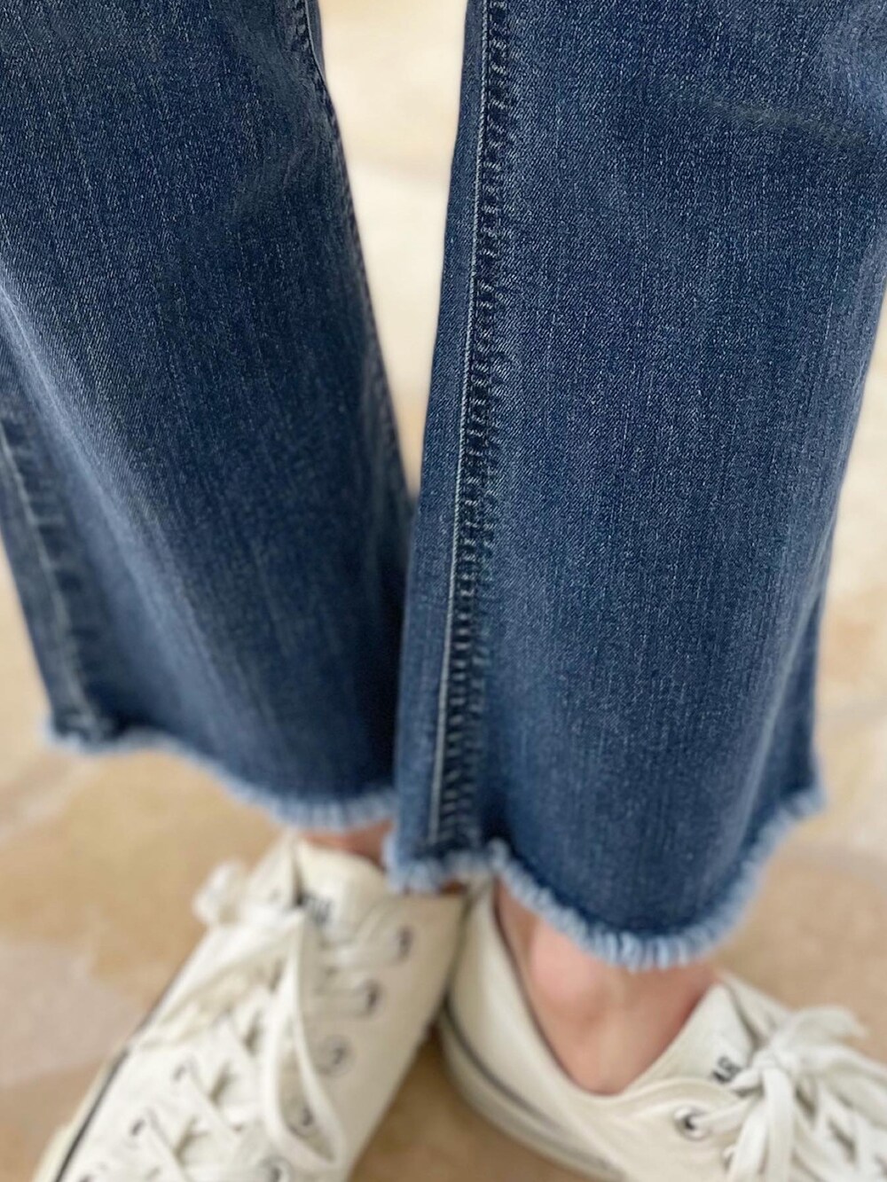 ブルー系のデニムパンツ、ホワイト系のトップス、ブルー系のタンクトップを着用したレディースの春コーディネートの5枚目の写真