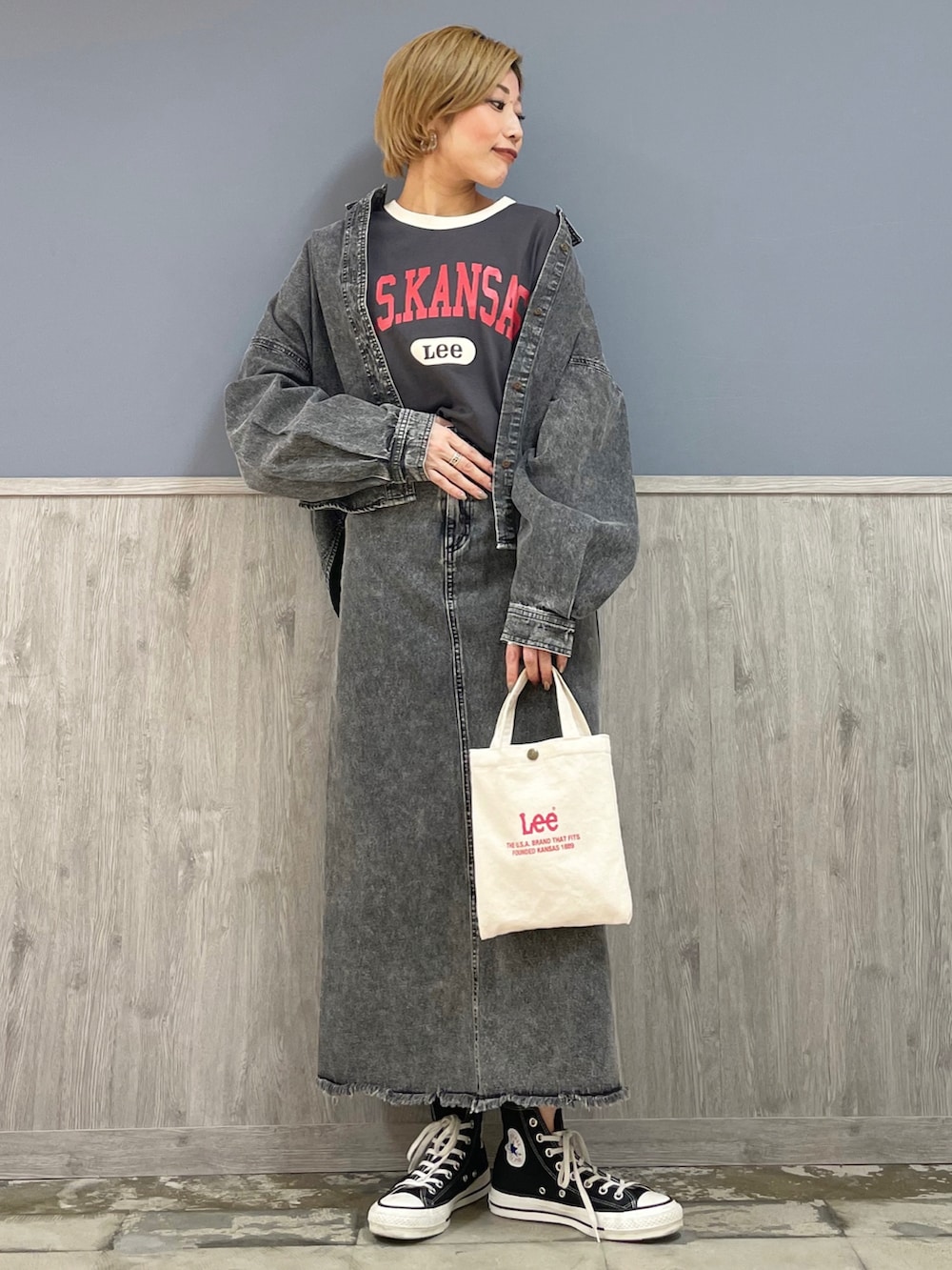 レッド系のショルダーバッグ、ブラック系のデニムスカート、グレー系のTシャツ/カットソーを着用したレディースの春コーディネートの2枚目の写真