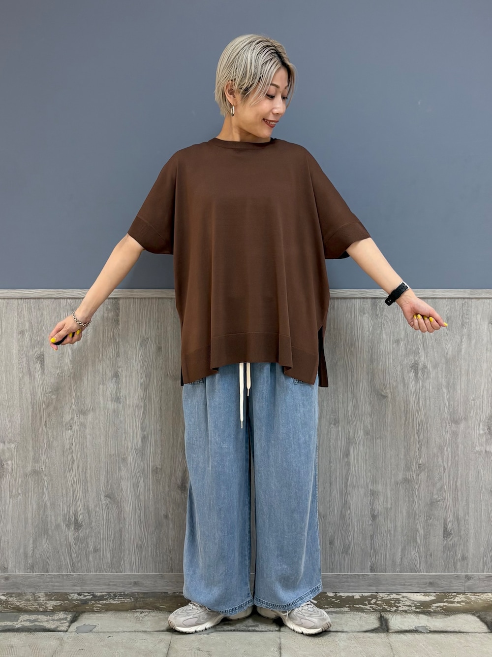 ブラウン系のニット/セーター、ブルー系のデニムパンツ、ベージュ系のキャップを着用したレディースの夏コーディネートの3枚目の写真