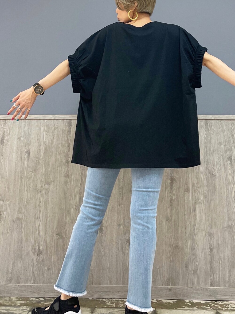 ブラック系のトップス、ブルー系のデニムパンツ、ブラック系のショルダーバッグを着用したレディースの夏コーディネートの5枚目の写真