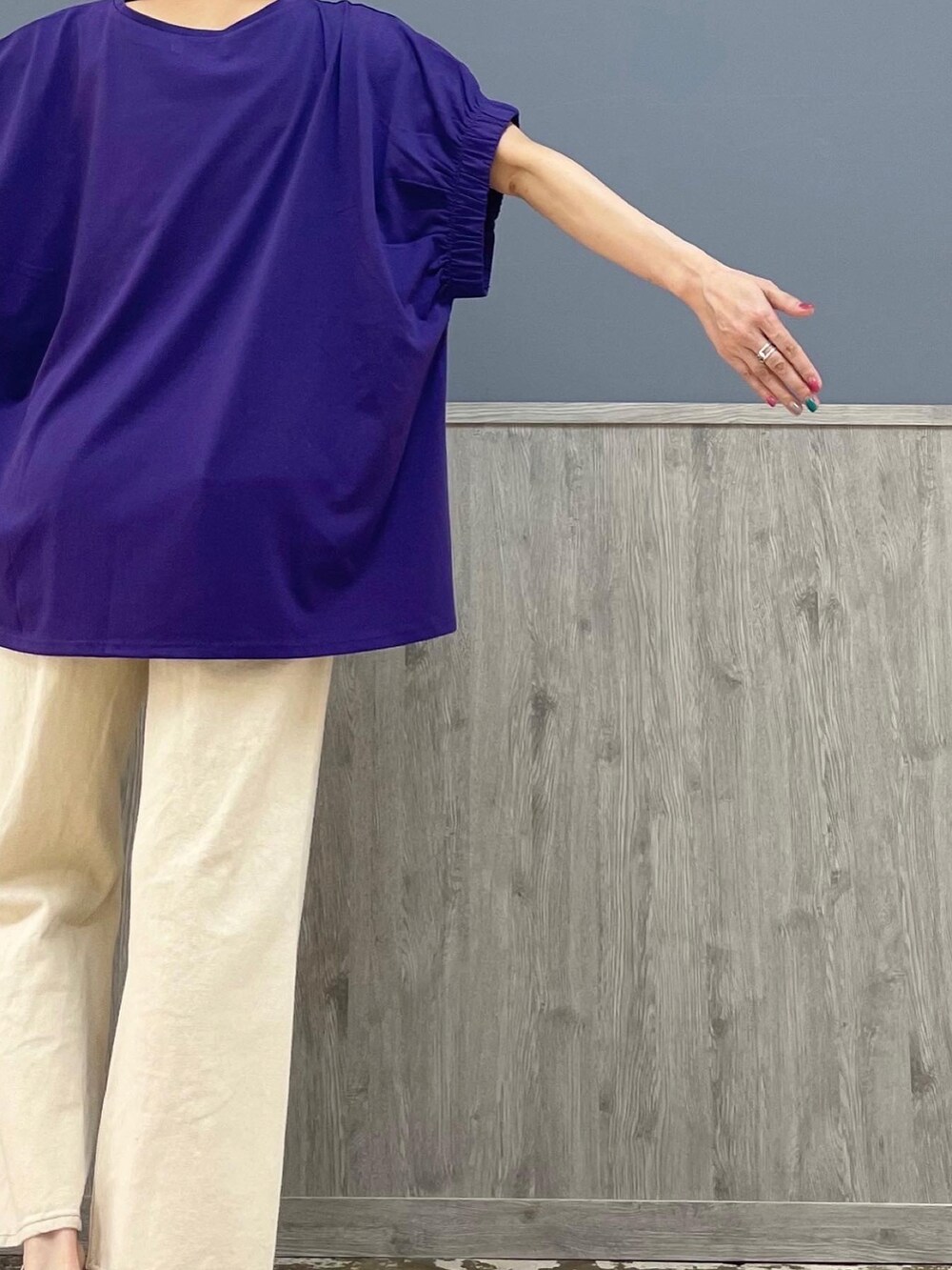 ホワイト系のデニムパンツ、ホワイト系のスニーカー、パープル系のトップスを着用したレディースの夏コーディネートの5枚目の写真