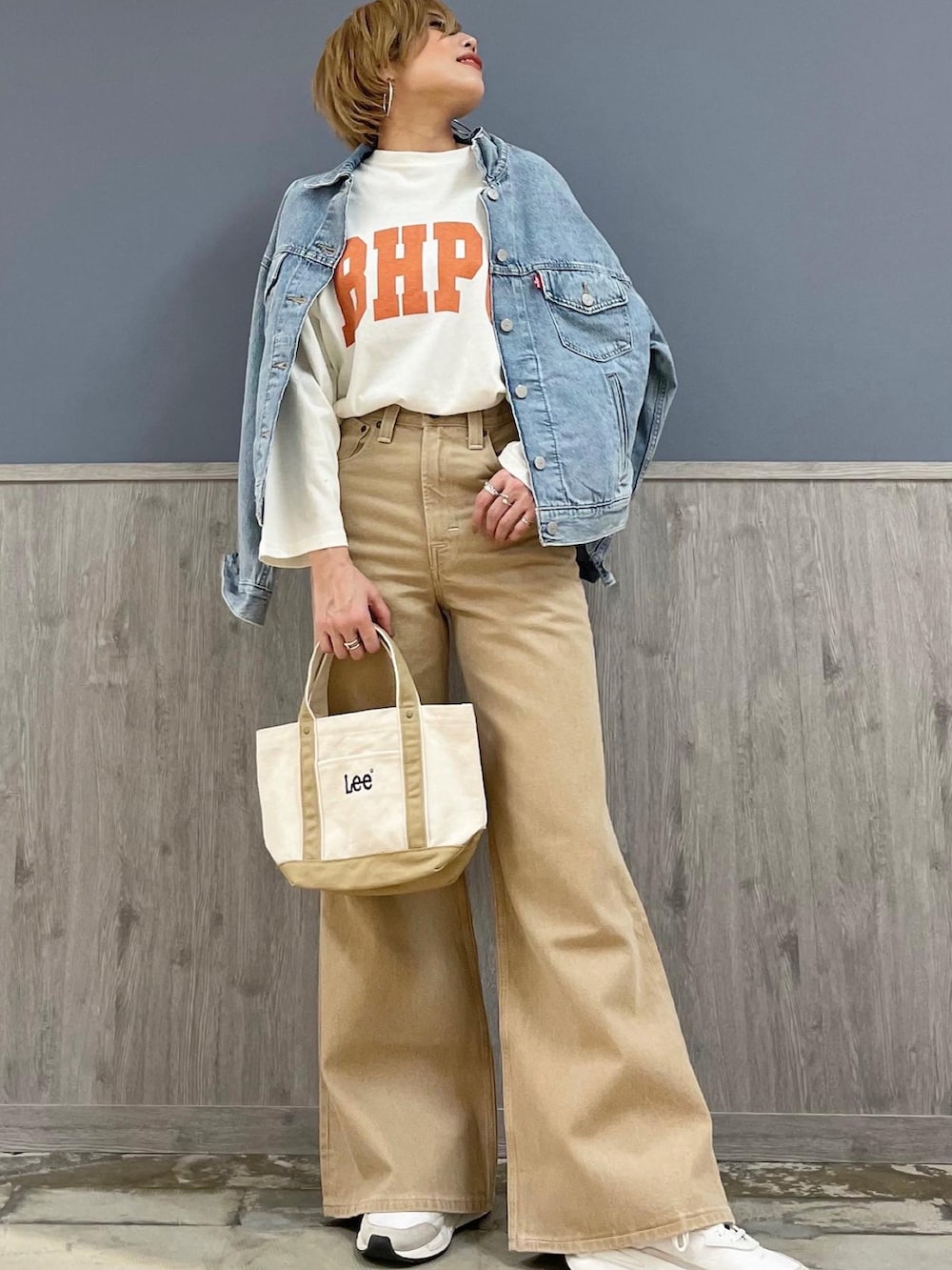 ブルー系のデニムジャケット、ホワイト系のTシャツ/カットソー、ベージュ系のデニムパンツを着用したレディースの春コーディネートの2枚目の写真