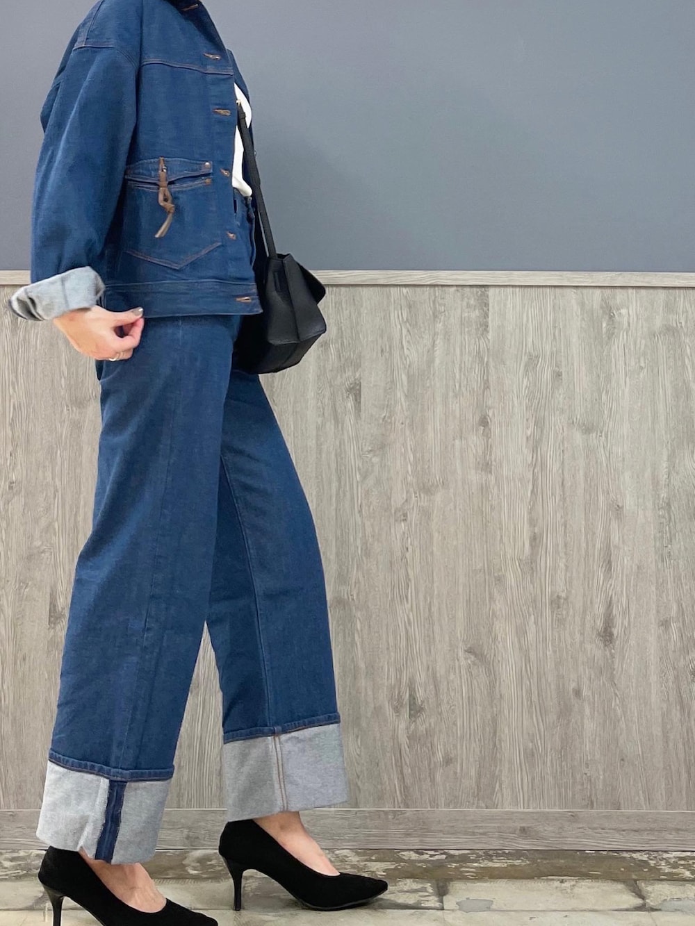 ブルー系のデニムパンツ、ブラック系のショルダーバッグ、ブルー系のデニムジャケットを着用したレディースの春コーディネートの2枚目の写真