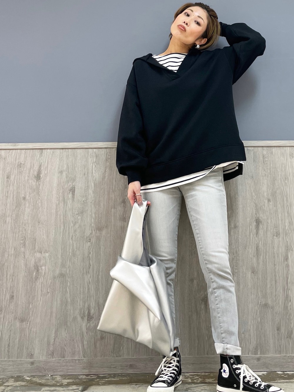 シルバー系のデニムパンツ、ブラック系のスニーカー、ブラック系のパーカーを着用したレディースの冬コーディネートの4枚目の写真