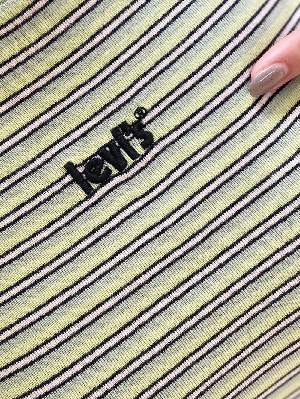 ブラック系のTシャツ/カットソー、ブルー系のシャツ/ブラウス、ベージュ系のパンツを着用したレディースの春コーディネートの5枚目の写真