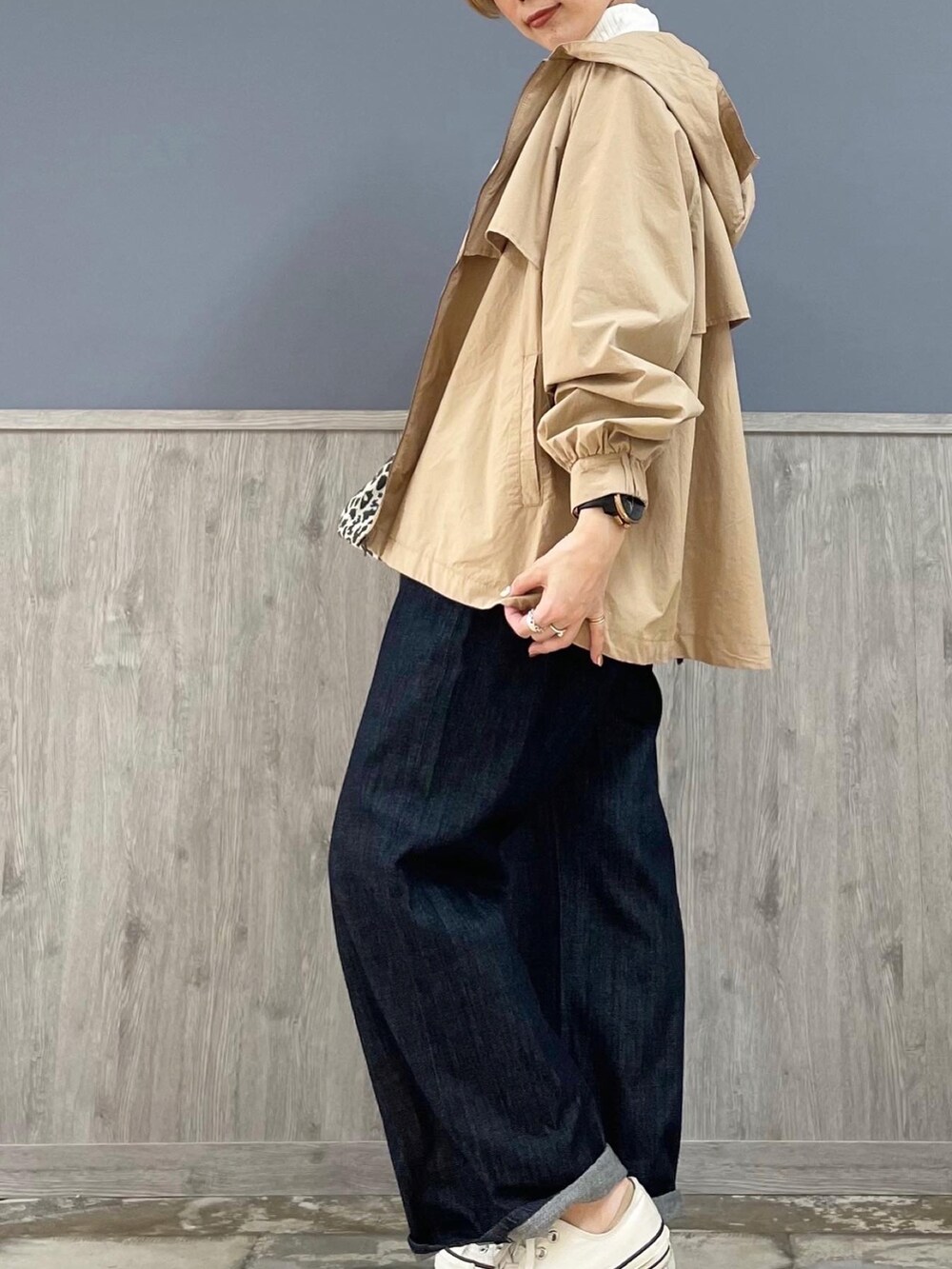 グレー系のショルダーバッグ、ベージュ系のマウンテンパーカー、ブルー系のサロペット/オーバーオールを着用したレディースの春コーディネートの2枚目の写真