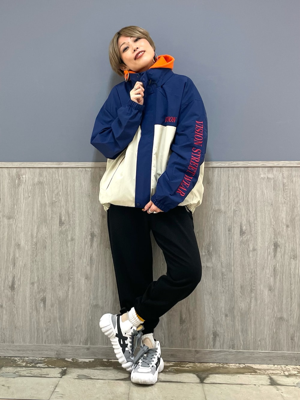 ブラック系のスウェットパンツ、オレンジ系のパーカー、ブラック系のボディバッグ/ウエストポーチを着用したレディースの冬コーディネートの3枚目の写真