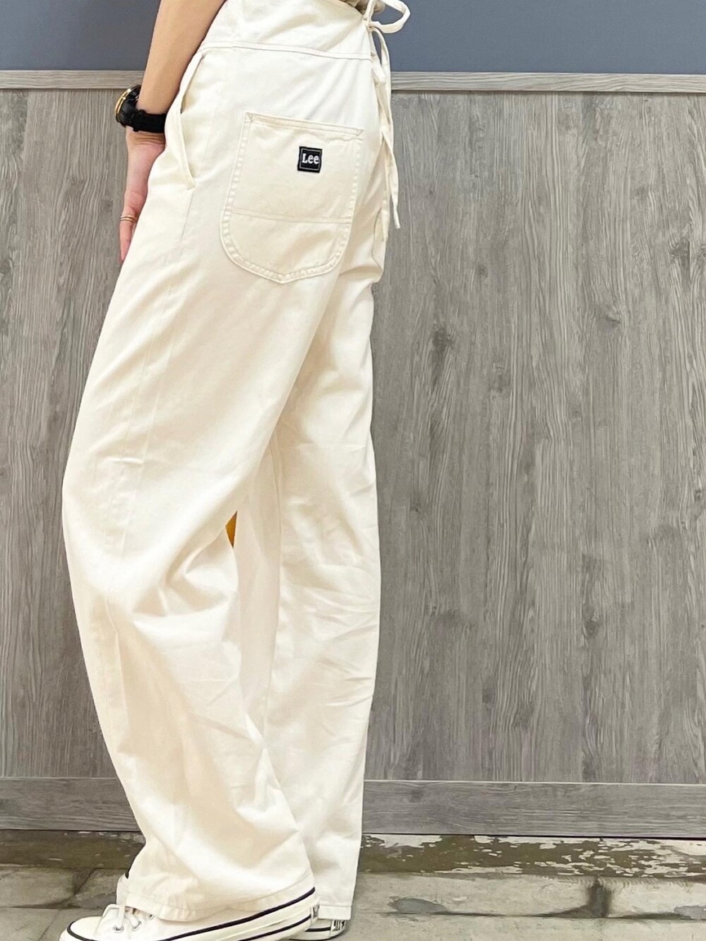 ベージュ系のショルダーバッグ、オレンジ系のカーディガン/ボレロ、ホワイト系のサロペット/オーバーオールを着用したレディースの夏コーディネートの5枚目の写真