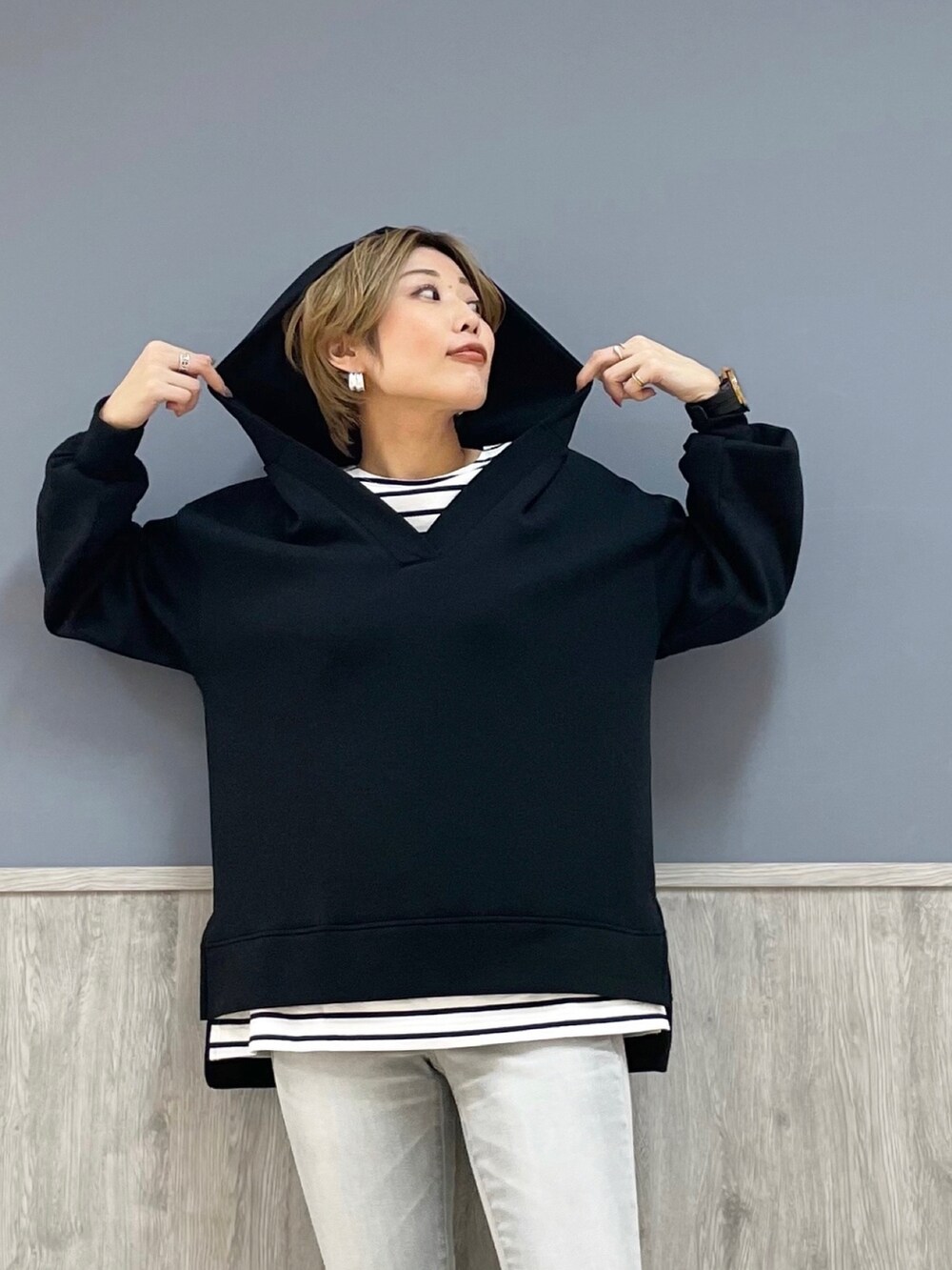 シルバー系のデニムパンツ、ブラック系のスニーカー、ブラック系のパーカーを着用したレディースの冬コーディネートの3枚目の写真