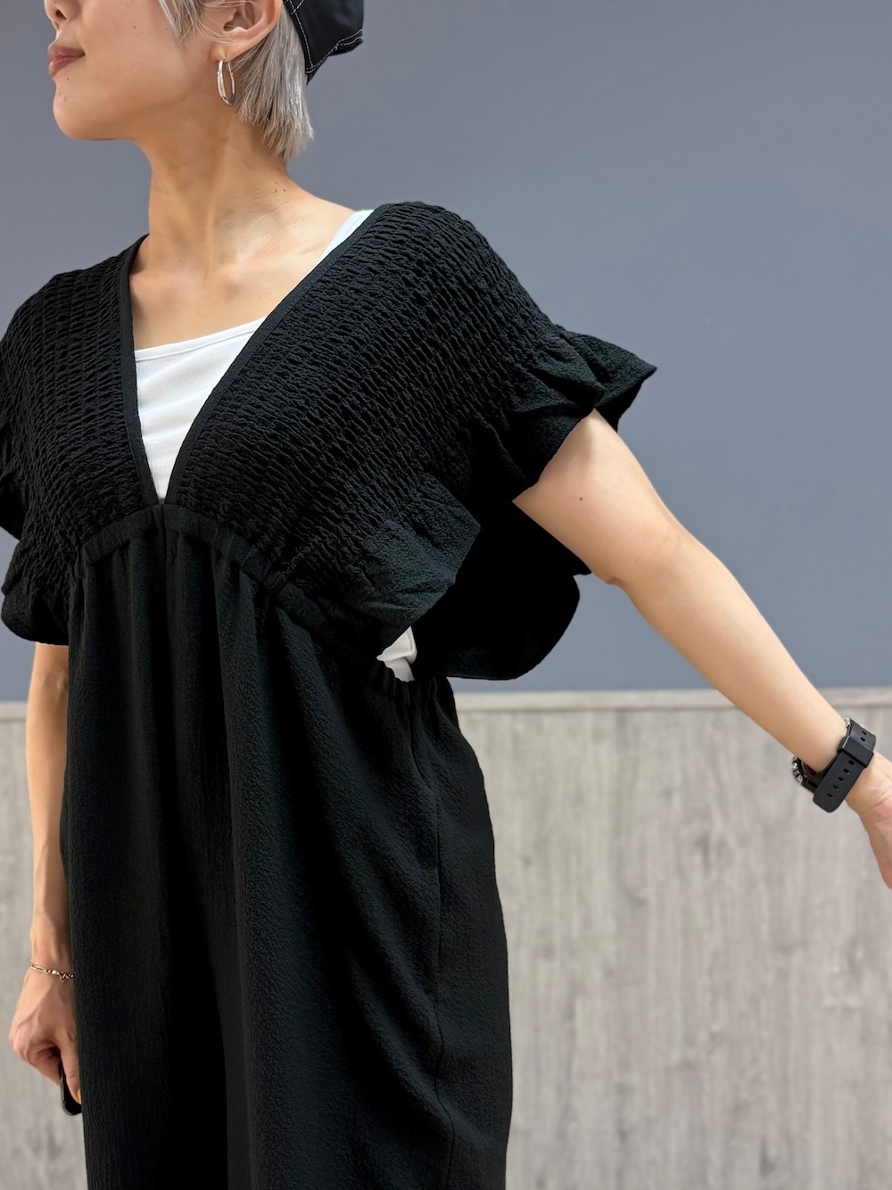ホワイト系のタンクトップ、グレー系のショルダーバッグ、ブラック系のキャップを着用したレディースの夏コーディネートの5枚目の写真