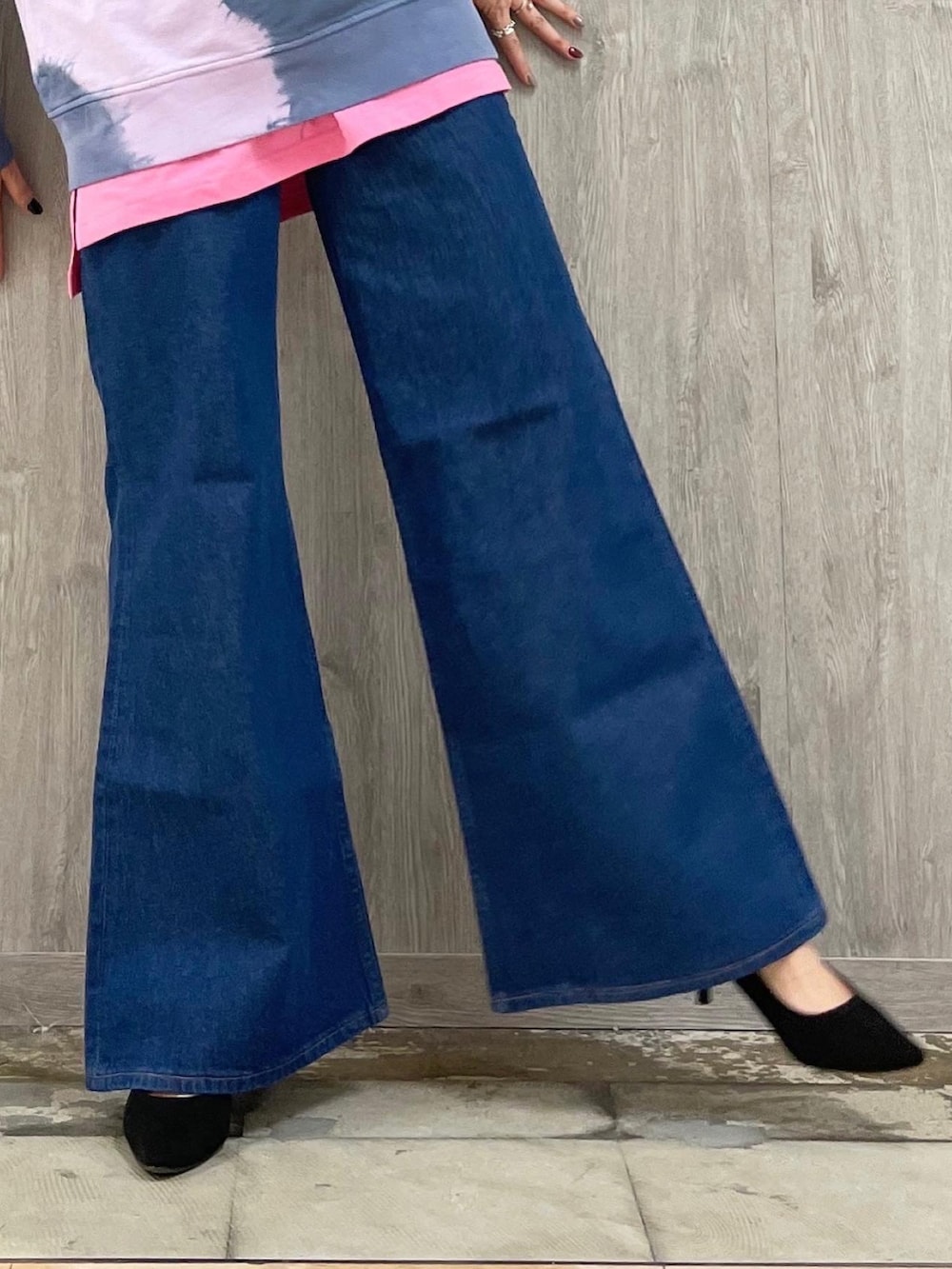 ブルー系のデニムパンツ、シルバー系のショルダーバッグ、パープル系のトップスを着用したレディースの春コーディネートの4枚目の写真