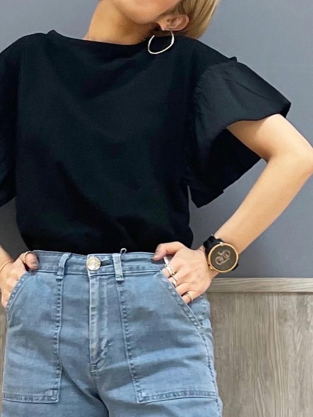 ブラック系のTシャツ/カットソー、ホワイト系のショルダーバッグ、ブルー系のデニムパンツを着用したレディースの春コーディネートの2枚目の写真