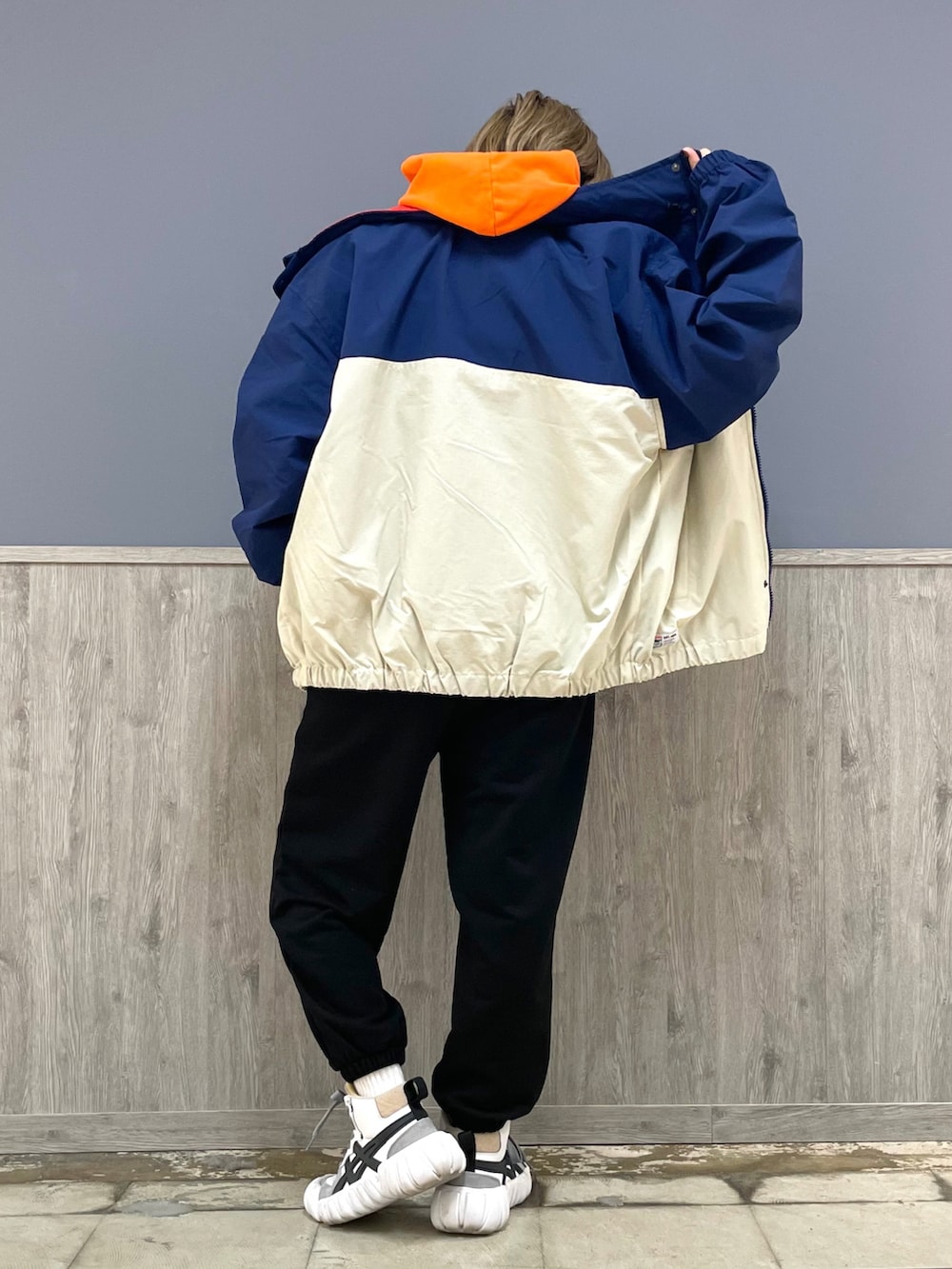 ブラック系のスウェットパンツ、オレンジ系のパーカー、ブラック系のボディバッグ/ウエストポーチを着用したレディースの冬コーディネートの5枚目の写真