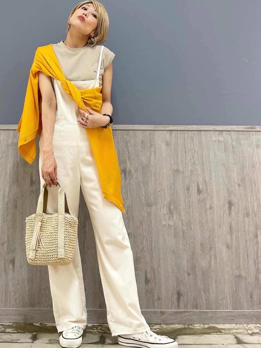 ベージュ系のショルダーバッグ、オレンジ系のカーディガン/ボレロ、ホワイト系のサロペット/オーバーオールを着用したレディースの夏コーディネートの3枚目の写真