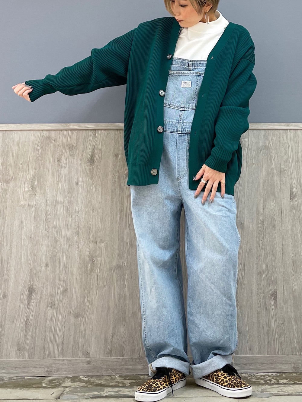 ブラウン系のトートバッグ、ブルー系のサロペット/オーバーオール、ホワイト系のTシャツ/カットソーを着用したレディースの冬コーディネートの3枚目の写真