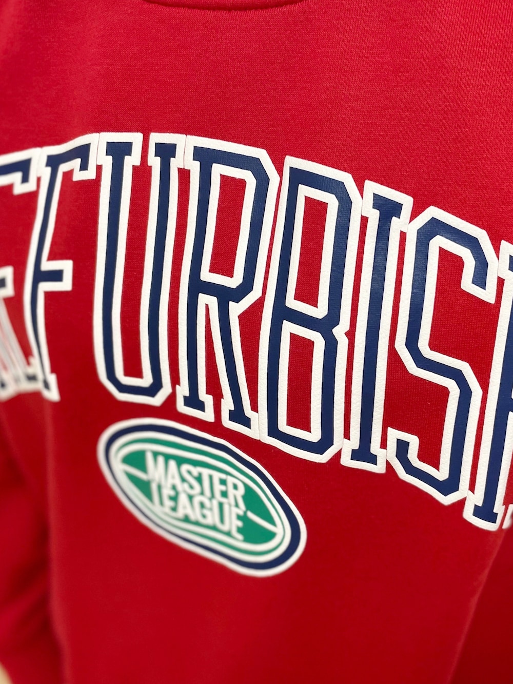 ブラック系のショルダーバッグ、レッド系のスウェット、ブルー系のデニムパンツを着用したレディースの春コーディネートの5枚目の写真