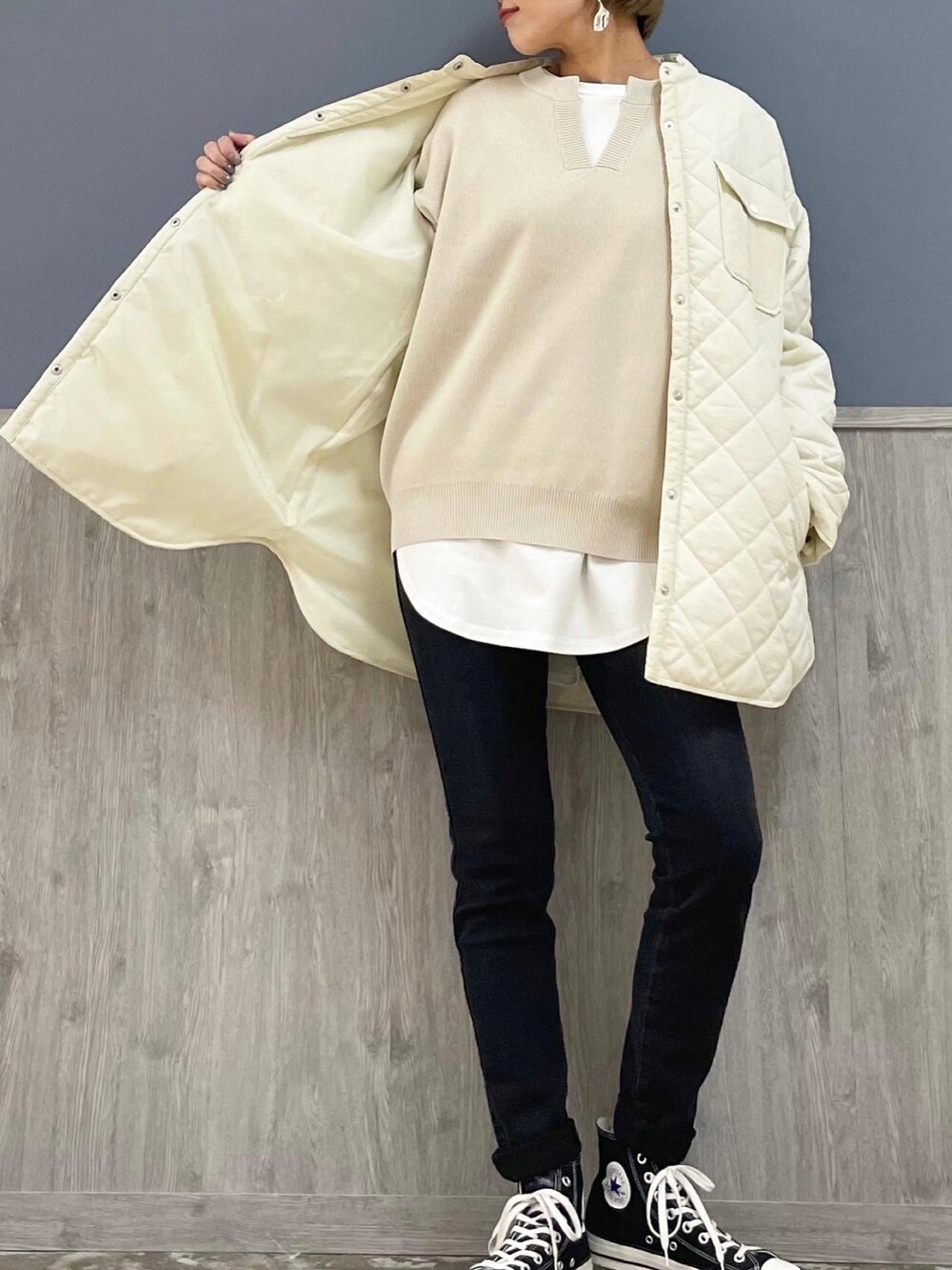 ブラック系のショルダーバッグ、ホワイト系のニット/セーター、ホワイト系のTシャツ/カットソーを着用したレディースの冬コーディネートの3枚目の写真