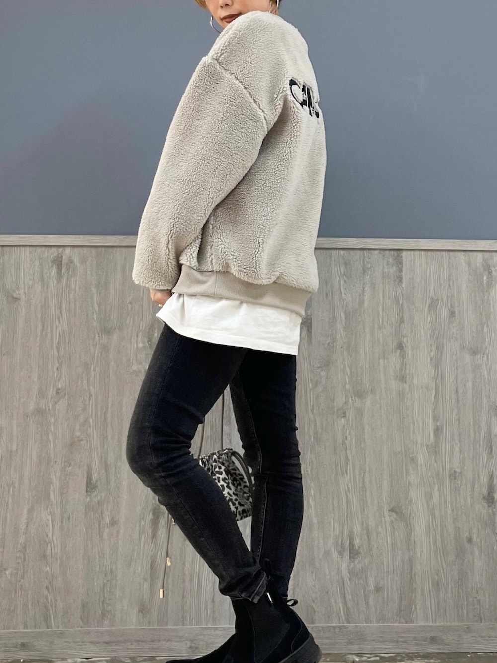 ブラック系のデニムパンツ、ホワイト系のTシャツ/カットソー、グレー系のスウェットを着用したレディースの冬コーディネートの3枚目の写真