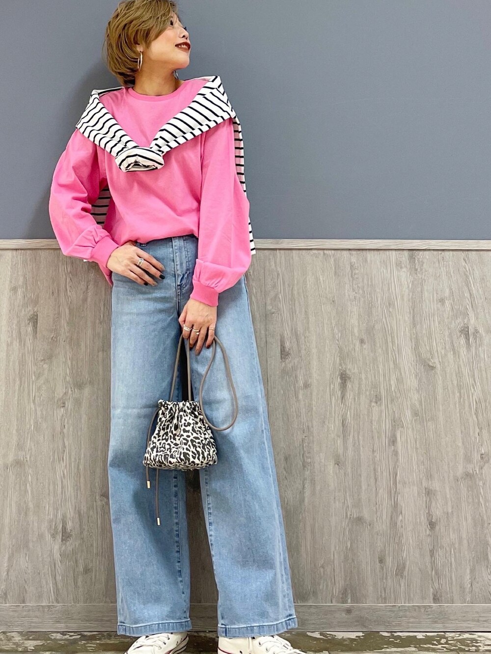 ブルー系のデニムパンツ、グレー系のショルダーバッグ、ピンク系のTシャツ/カットソーを着用したレディースの春コーディネートの2枚目の写真