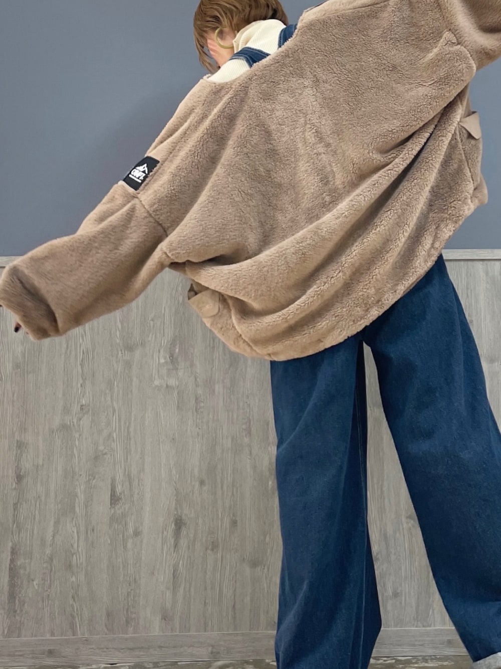 ベージュ系のその他アウター、ブルー系のサロペット/オーバーオール、ホワイト系のニット/セーターを着用したレディースの秋コーディネートの2枚目の写真