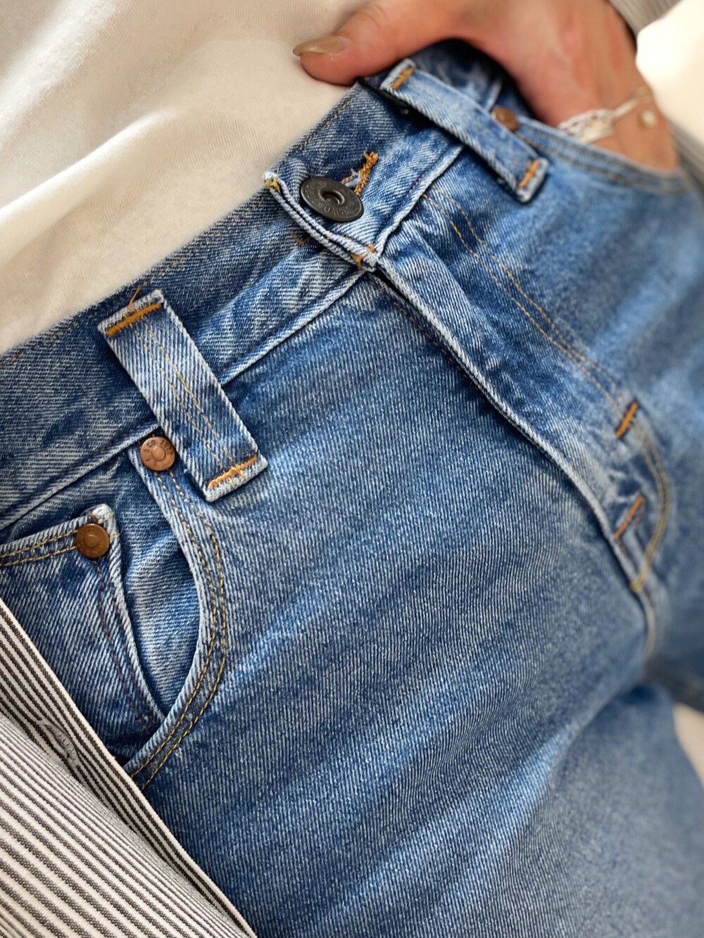 レッド系のTシャツ/カットソー、ブルー系のシャツ/ブラウス、ブルー系のデニムパンツを着用したレディースの冬コーディネートの5枚目の写真