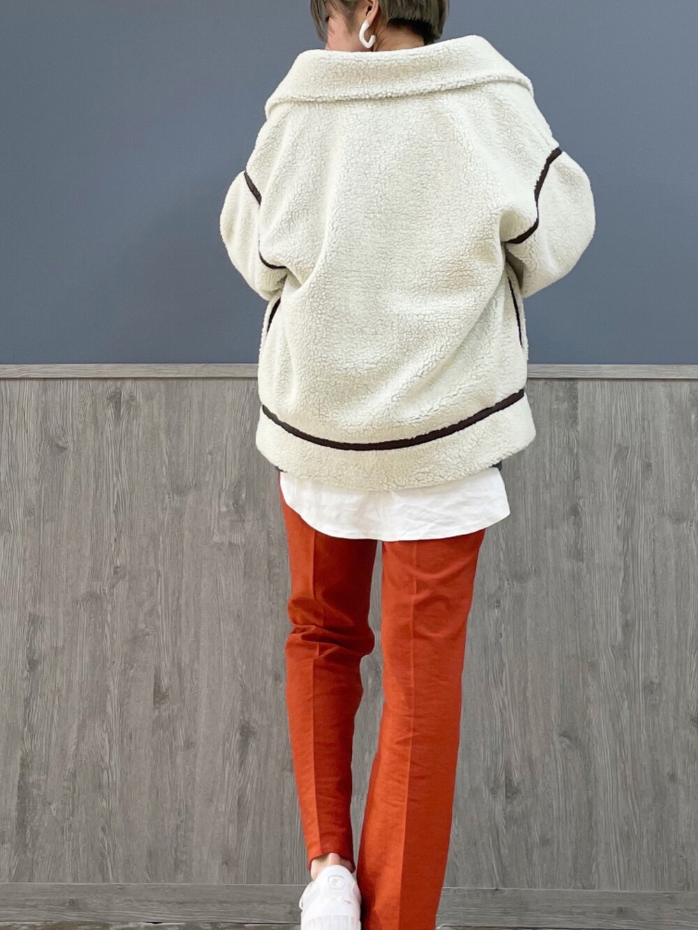 オレンジ系のスラックス、ブルー系のパーカー、ホワイト系のその他アウターを着用したレディースの秋コーディネートの3枚目の写真