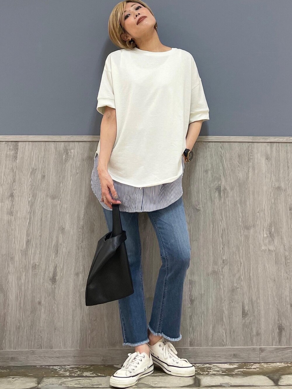 ブルー系のデニムパンツ、ホワイト系のトップス、ブルー系のタンクトップを着用したレディースの春コーディネートの3枚目の写真