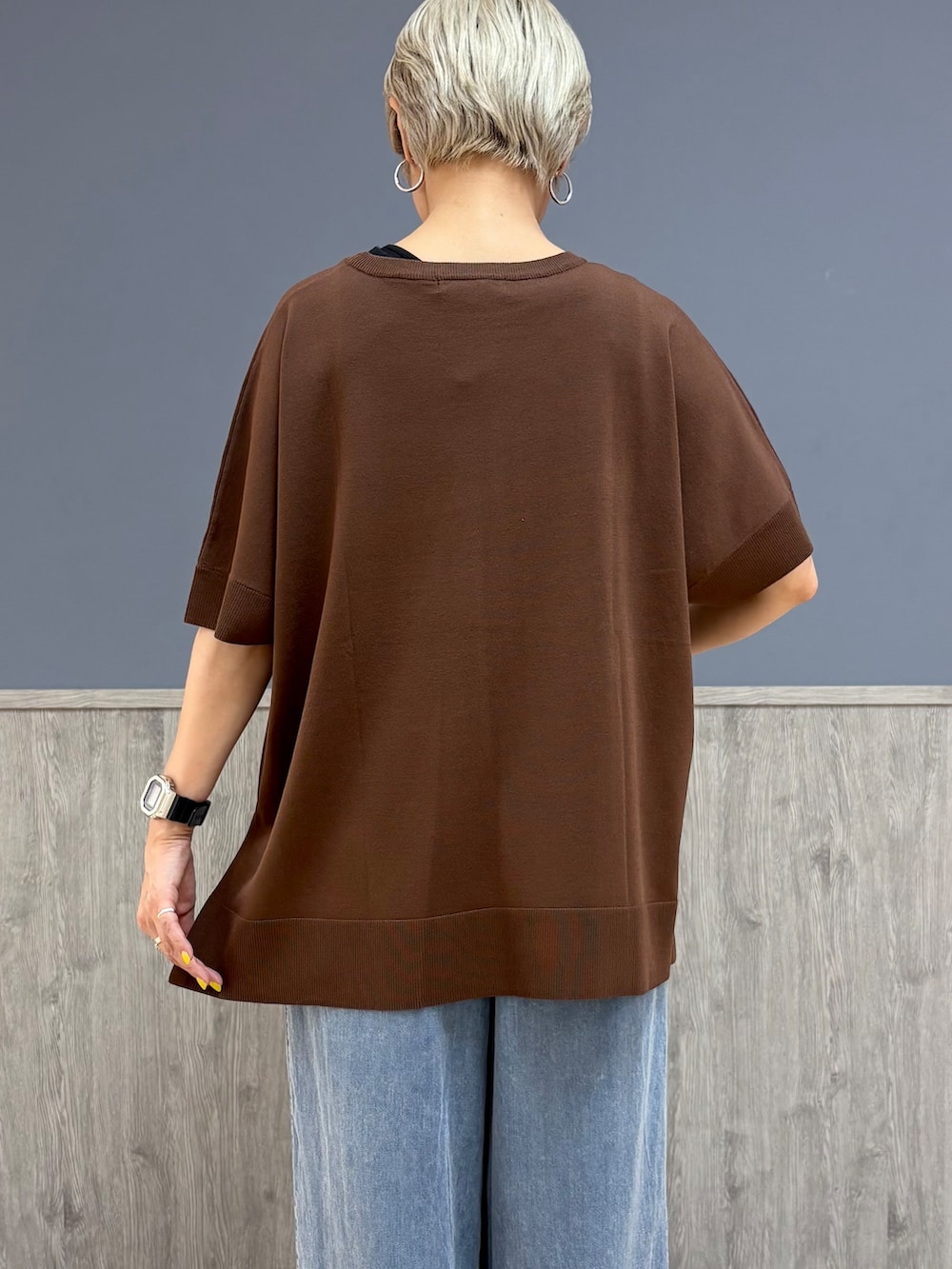 ブラウン系のニット/セーター、ブルー系のデニムパンツ、ベージュ系のキャップを着用したレディースの夏コーディネートの5枚目の写真