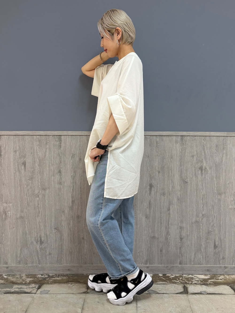 ブルー系のデニムパンツ、ブラック系のショルダーバッグ、ブラック系のキャップを着用したレディースの夏コーディネートの4枚目の写真