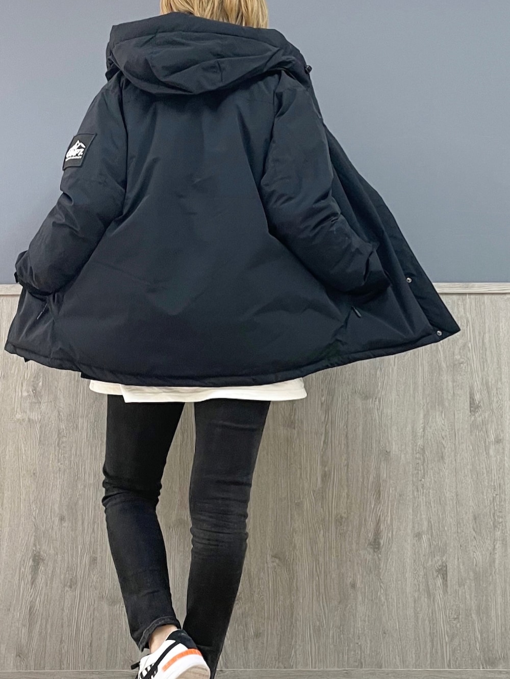 ブラック系のデニムパンツ、ブラック系のダウンジャケット/コート、ホワイト系のTシャツ/カットソーを着用したレディースの秋コーディネートの4枚目の写真